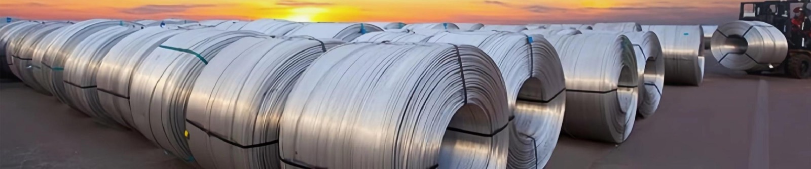 Coils of aluminium rod stacked at sunset